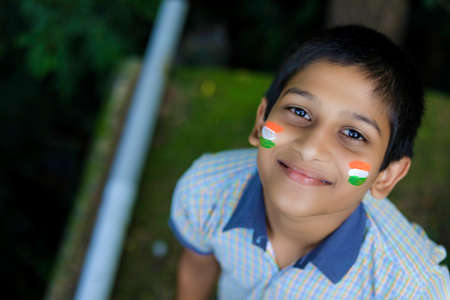 young indian child with indian flag on faceの写真素材