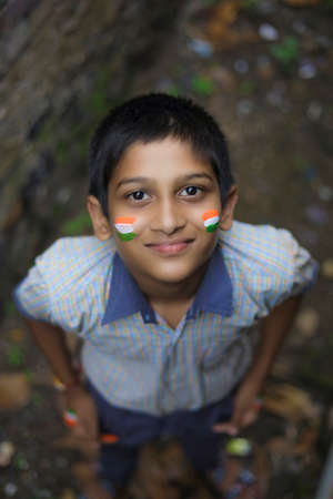 young indian child with indian flag on faceの写真素材