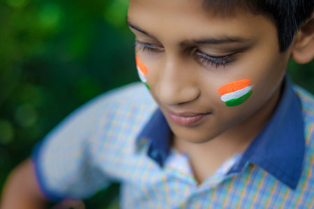 young indian child with indian flag on faceの写真素材