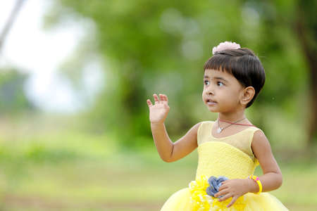 Cute indian baby child giving expression over nature background