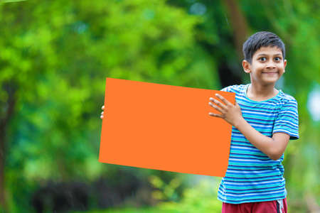 kid planting tree and showing empty boardの写真素材