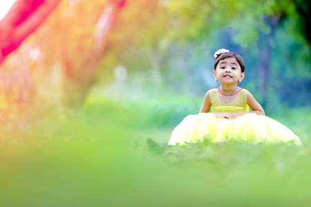 Cute indian baby child giving expression over nature backgroundの写真素材
