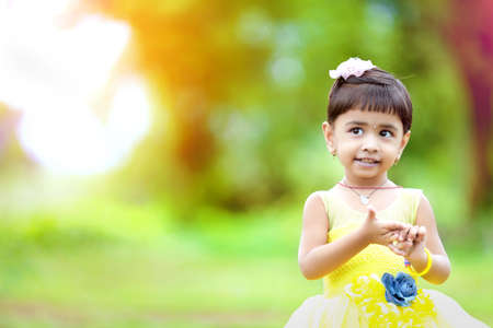 Cute indian baby child giving expression over nature background