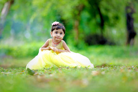 Cute indian baby child giving expression over nature backgroundの写真素材