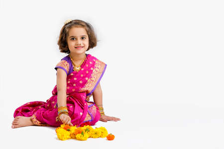 Cute indian little girl in traditional wear and showing expression on white backgroundの写真素材