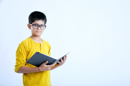 Young indian cute child reading a bookの写真素材