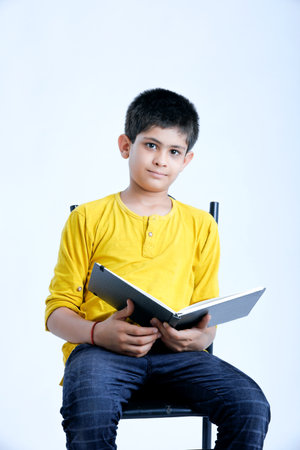 Young indian cute child reading a book