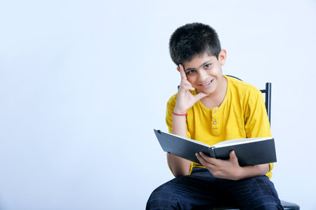 Young indian cute child reading a book