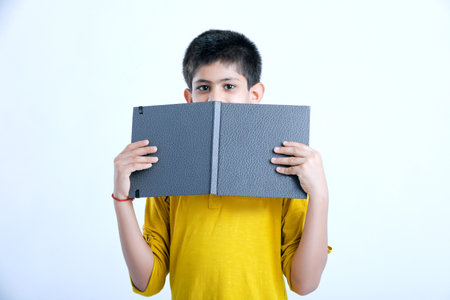 Young indian cute child reading a bookの写真素材