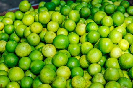 Green and yellow lemon in indian vegetable marketの写真素材