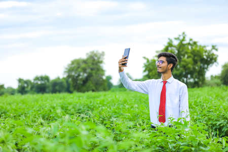 Technology and people concept, Young indian agronomist with tablet at field