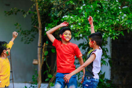 Cute indian little childâ€™s group playing holi. Holi is colors festival in india