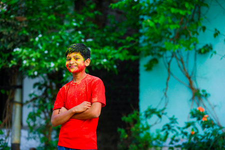 Holi celebrations -Indian little boy playing Holi and showing face expression.