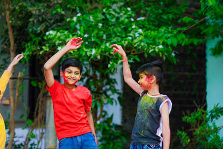 Cute indian little childâ€™s group playing holi. Holi is colors festival in india