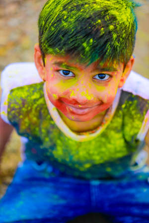 Holi celebrations -Indian little boy playing Holi and showing face expression.