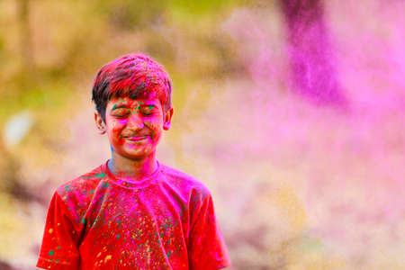 Holi celebrations -Indian little boy playing Holi and showing face expression.の写真素材