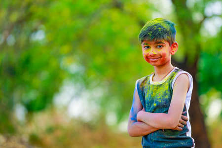 Holi celebrations -Indian little boy playing Holi and showing face expression.