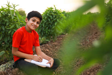 Cute indian little child studying at agriculture fieldの写真素材