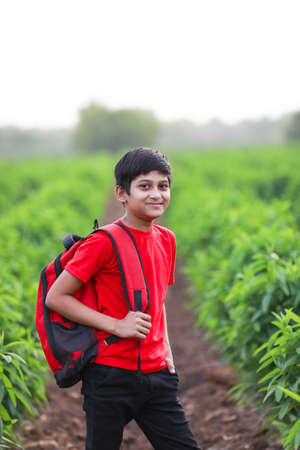Cute indian child with sack bag at agriculture fieldの写真素材