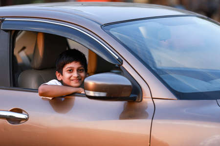 Cute Indian Child waving from car windowの写真素材