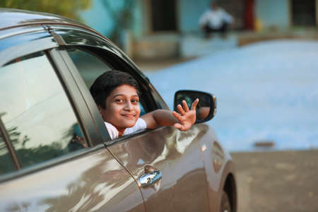 Cute Indian Child waving from car windowの写真素材