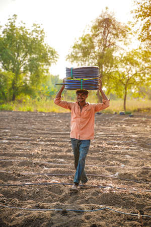 Indian farmer or labour Drip irrigation pipe assemble in agriculture field. rural scene.の写真素材