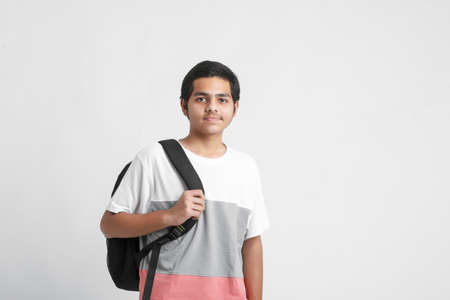Young indian college student holding bag on white background.