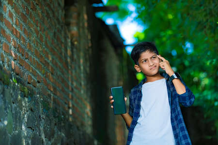 young indian cute child with smartphoneの写真素材