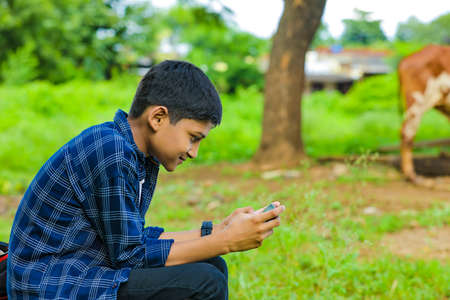 Cute indian schoolboy studying online on tablet at home
