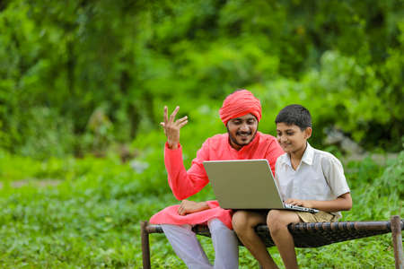 Technology concept : Indian farmer child using laptop