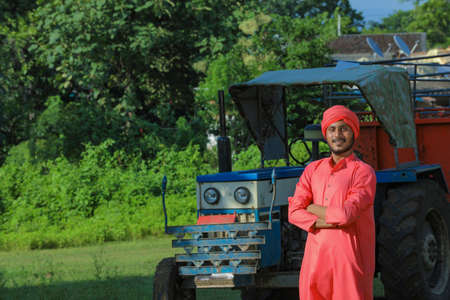 Indian farmer standing with new tractor at fieldの写真素材