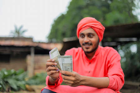 Young indian farmer counting money