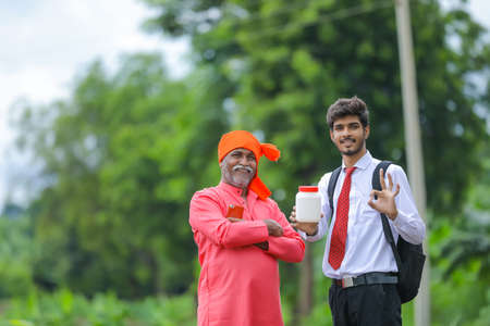 indian farmer showing agro product bottle with agronomistの写真素材