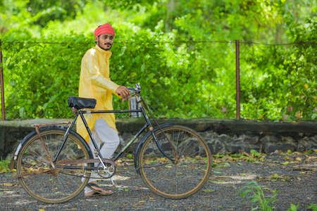 Young indian farmer or labor going to work by cycleの写真素材