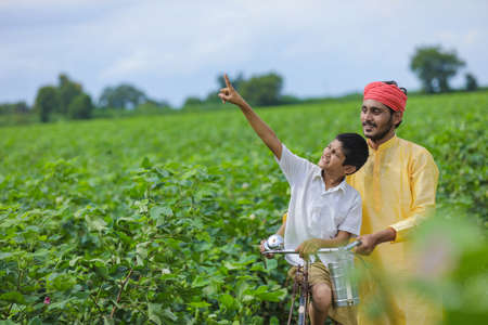 Indian farmer or labor with his child at cotton fieldの写真素材