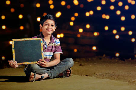 Young indian cute child showing slateの写真素材