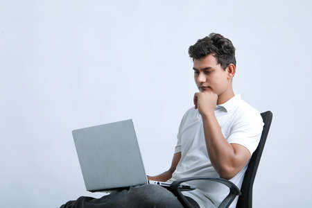 young indian man using laptop.