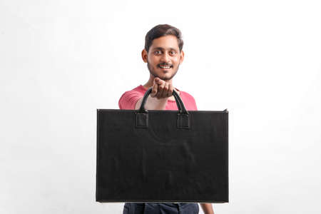 Young indian man showing excitement with shopping bagsの写真素材