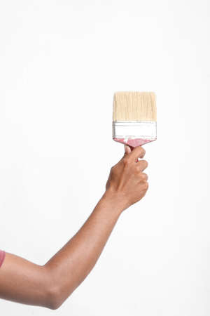 male hand and red brush isolated on white backgroundの写真素材
