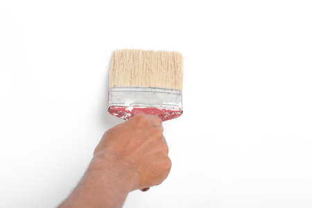 male hand and red brush isolated on white backgroundの写真素材