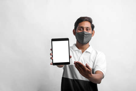 young indian man showing tablet over white background.