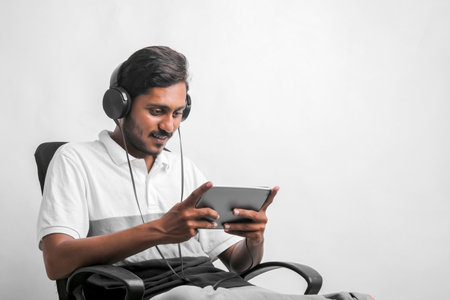 Young indian man using tablet over white background.の写真素材