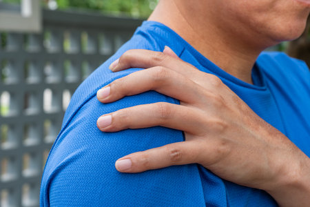 Asian male experiencing shoulder pain from routine choresâhighlighting joint stress, muscle strain, and the need for recovery. Ideal for medical, physiotherapy, or wellness themed.の写真素材