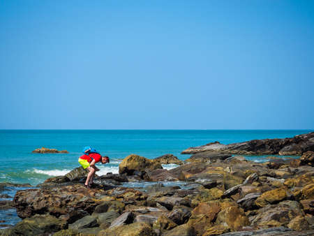 the tourist looking for something in back stone on the beach at Lanta Island Krabi Thailand, 13Mar2020のeditorial素材
