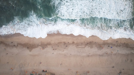 Aerial view of a beautiful beach with waves crashing on the sandの写真素材