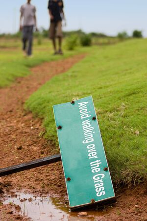 Two people walking over the path of grassland の写真素材
