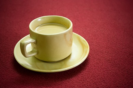 Cup of hot tea over red carpet background  の写真素材