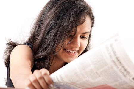 pretty indian  woman reading the newspaper and smilling の写真素材