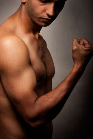 Portrait of young Indian angry man over dark background