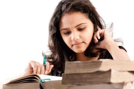 Young indian girl leaned over pile of books, isolated on whiteの写真素材